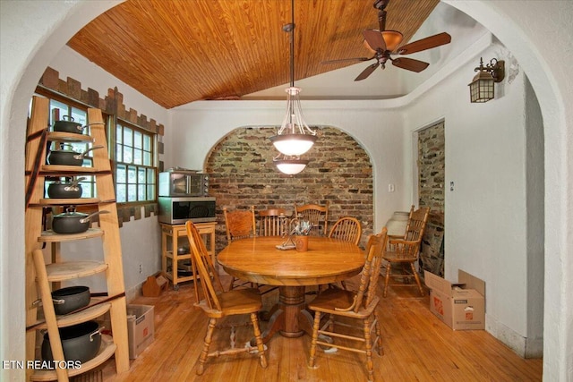 dining space featuring arched walkways, wooden ceiling, vaulted ceiling, and wood-type flooring