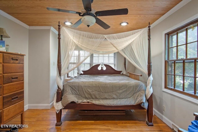 bedroom featuring multiple windows, ornamental molding, and wood finished floors