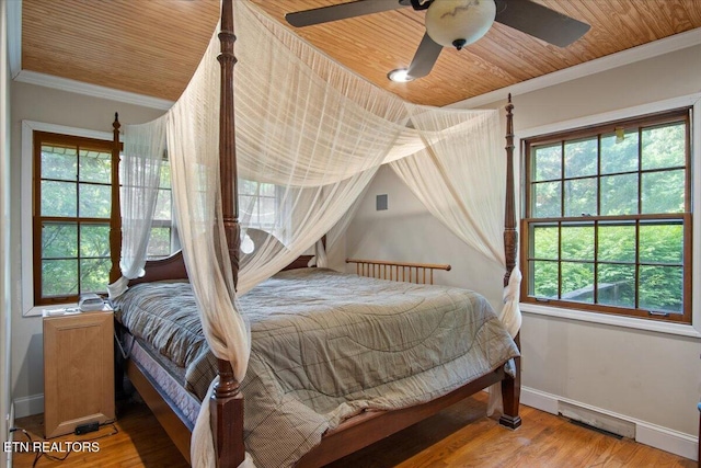 bedroom with light wood-type flooring, wooden ceiling, baseboards, and crown molding