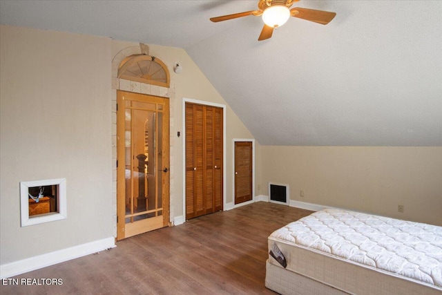 bedroom with lofted ceiling, wood finished floors, a ceiling fan, visible vents, and baseboards