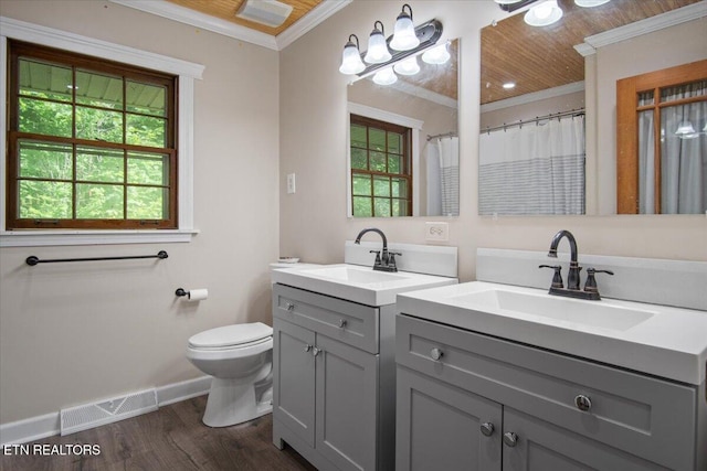 bathroom with visible vents, wood finished floors, a sink, and ornamental molding