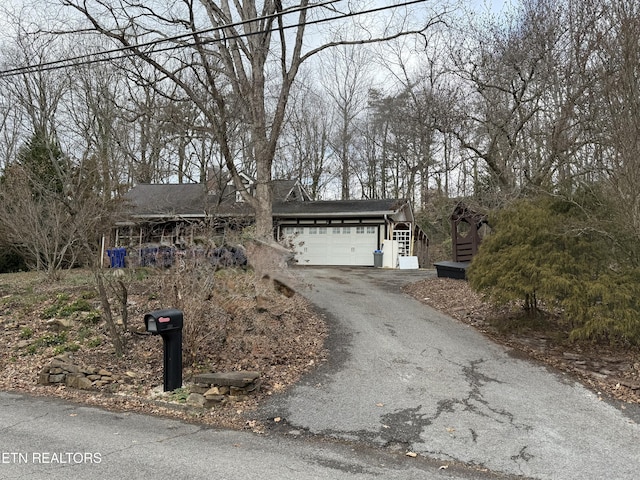 view of front of property featuring an attached garage and aphalt driveway