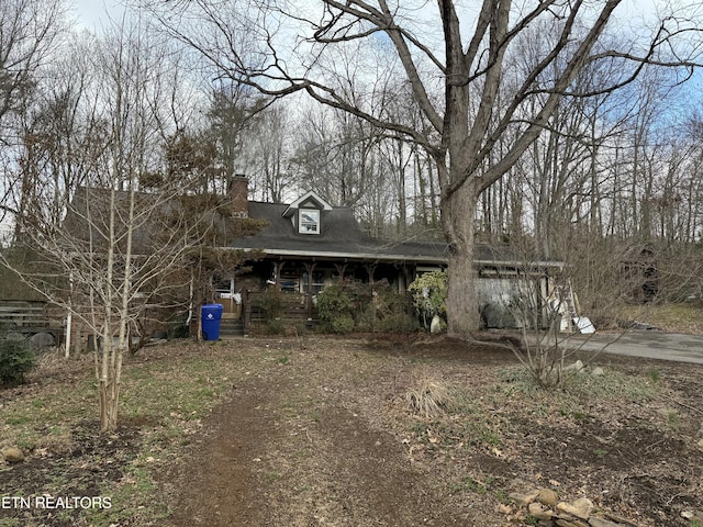 view of front facade featuring a porch and a chimney