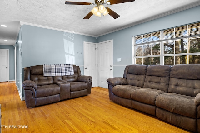 living area featuring light wood finished floors, ceiling fan, crown molding, a textured ceiling, and recessed lighting