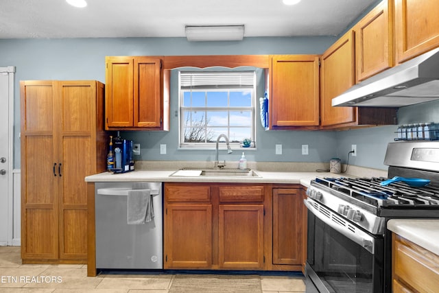 kitchen with stainless steel appliances, a sink, light countertops, and under cabinet range hood