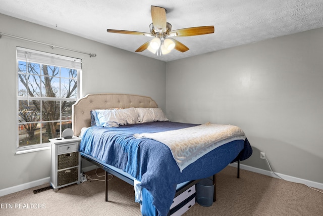 carpeted bedroom featuring a textured ceiling, a ceiling fan, and baseboards