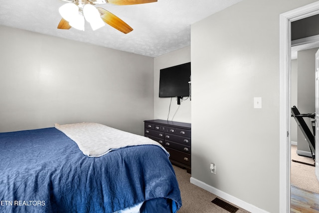 bedroom featuring visible vents, baseboards, a ceiling fan, carpet, and a textured ceiling