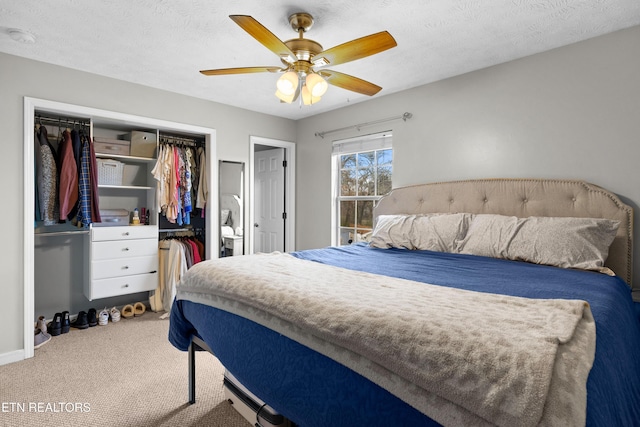 bedroom with carpet, a closet, ceiling fan, and a textured ceiling