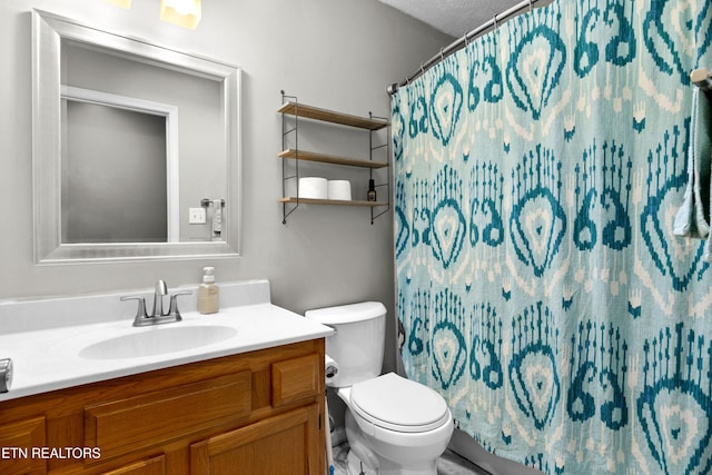 bathroom with a shower with shower curtain, vanity, and toilet