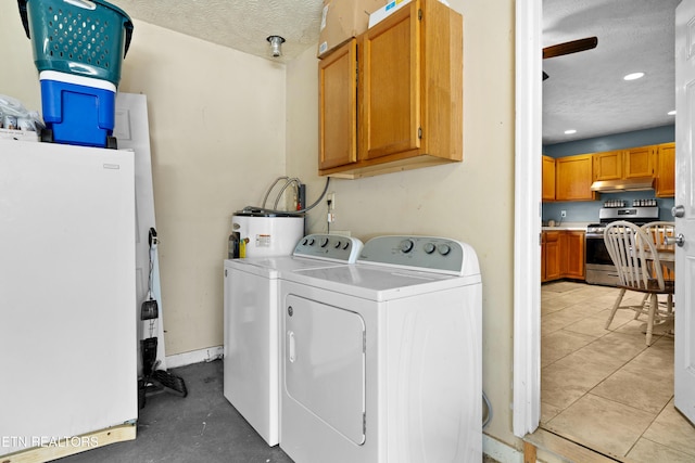 laundry room with a textured ceiling, recessed lighting, water heater, independent washer and dryer, and cabinet space