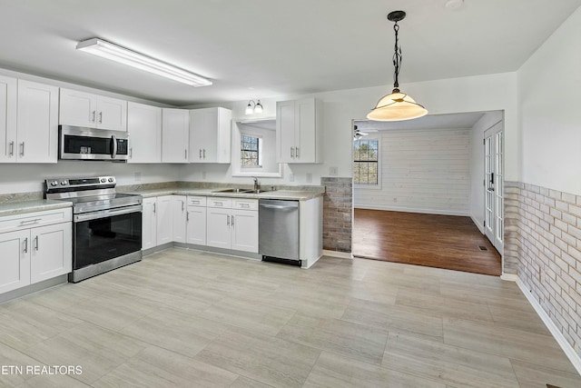 kitchen featuring white cabinets, a sink, stainless steel appliances, and light countertops