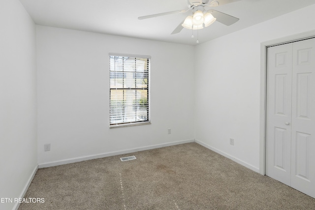 unfurnished room with a ceiling fan, baseboards, visible vents, and carpet flooring