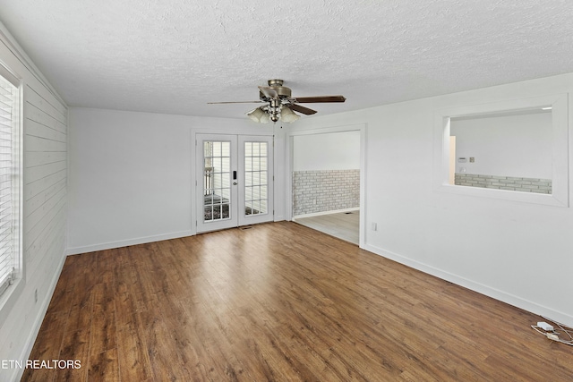 unfurnished room featuring a textured ceiling, french doors, wood finished floors, and a ceiling fan