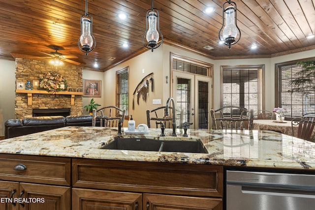 kitchen with french doors, ornamental molding, wood ceiling, a sink, and a stone fireplace