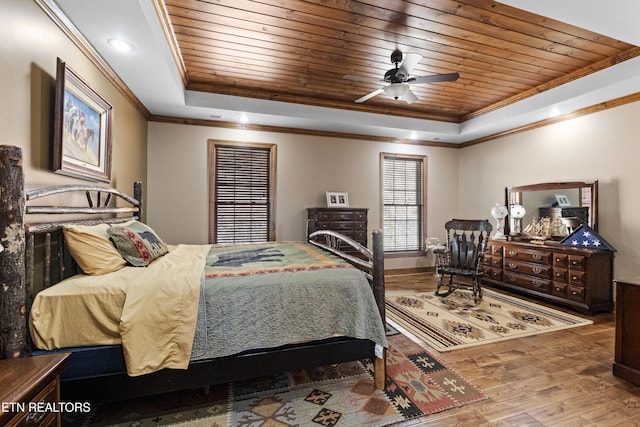 bedroom with a tray ceiling, wooden ceiling, wood finished floors, and crown molding