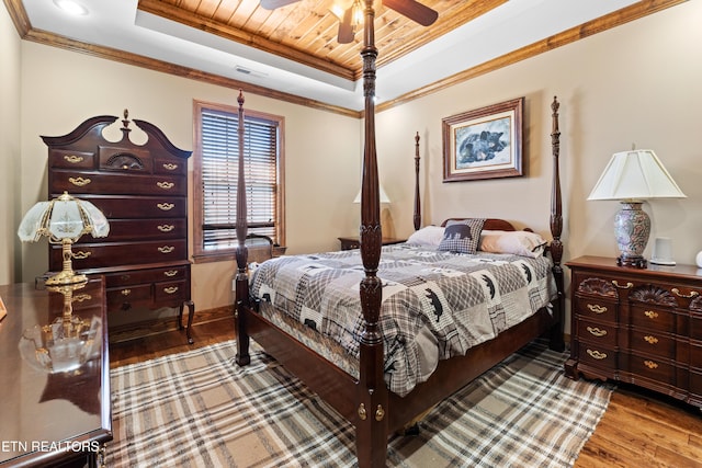 bedroom featuring wood finished floors, wood ceiling, visible vents, ornamental molding, and a raised ceiling