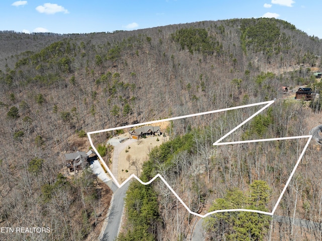 birds eye view of property featuring a view of trees