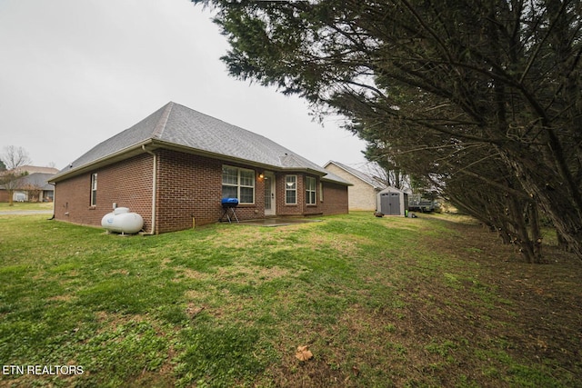 rear view of house featuring brick siding, an outdoor structure, a lawn, and a shed