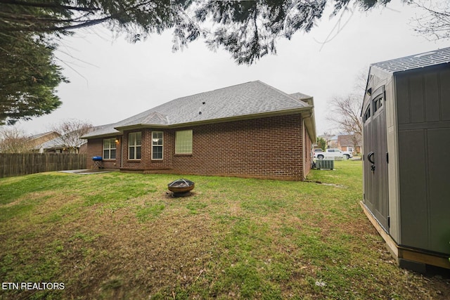 rear view of property with a yard, fence, and brick siding