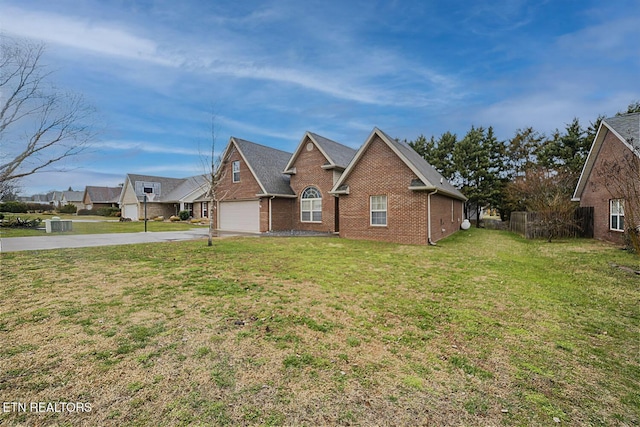 traditional home featuring an attached garage, brick siding, driveway, and a front lawn