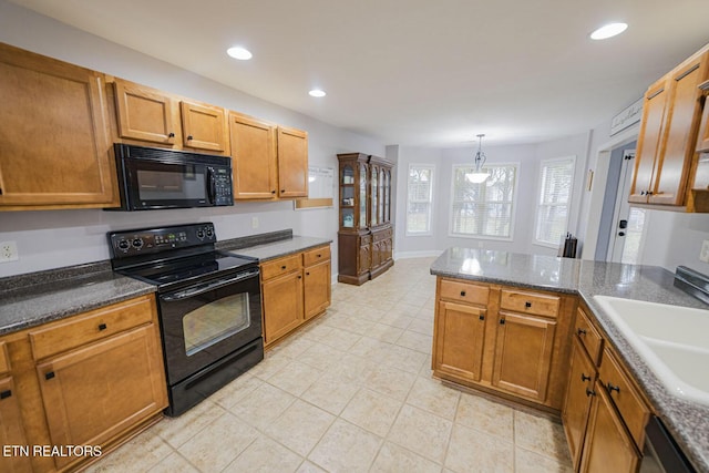 kitchen featuring black appliances, brown cabinetry, a sink, and recessed lighting