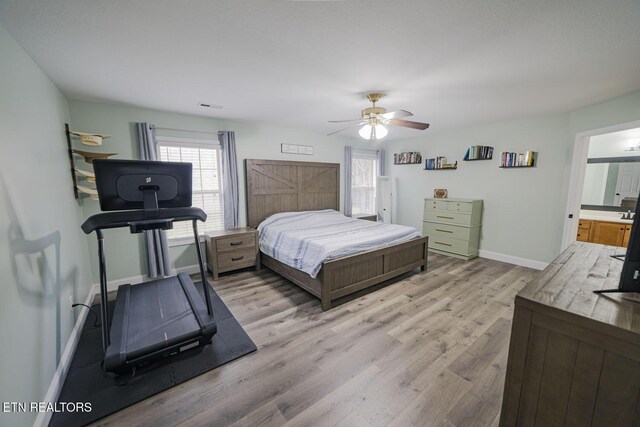 bedroom featuring visible vents, a ceiling fan, light wood-style flooring, and baseboards