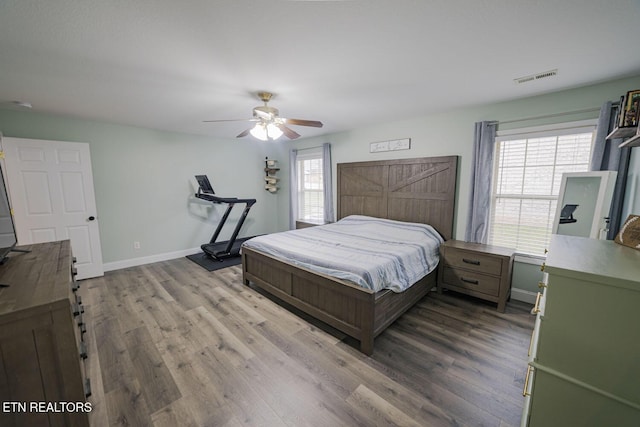 bedroom featuring visible vents, multiple windows, and wood finished floors