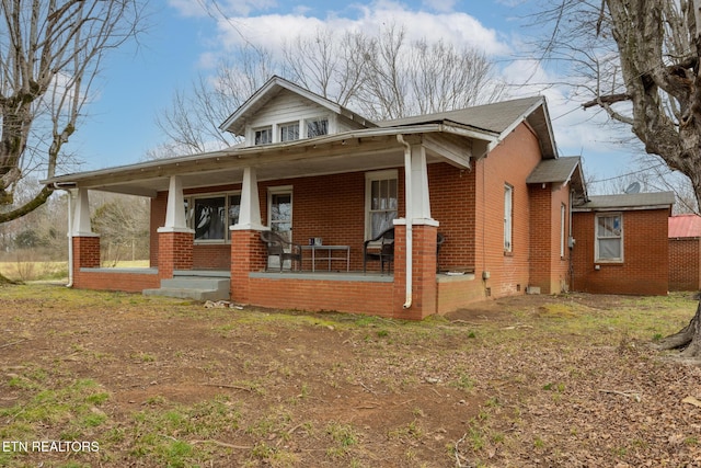 bungalow-style home featuring brick siding and covered porch