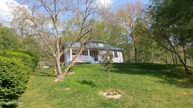 view of front facade with a front yard and covered porch