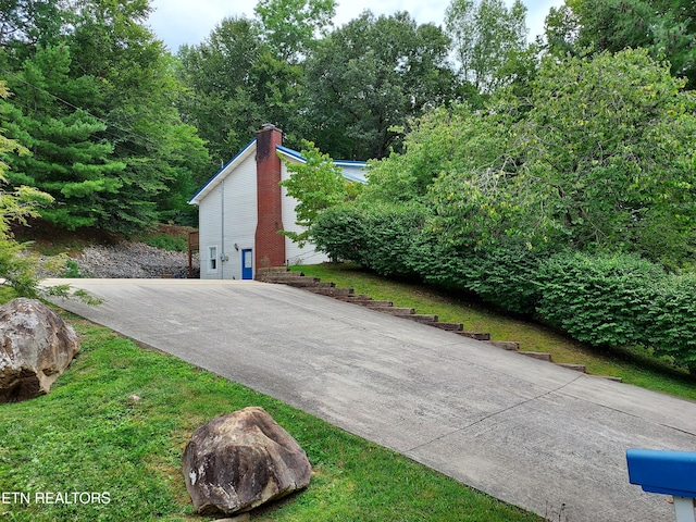 exterior space featuring driveway and a chimney