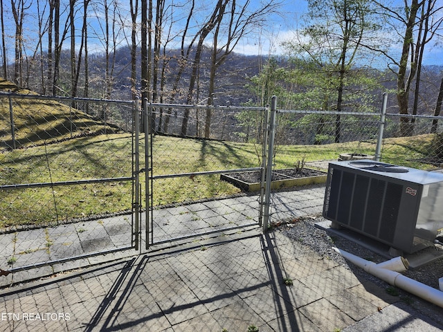 view of patio featuring central AC unit, fence, and a gate