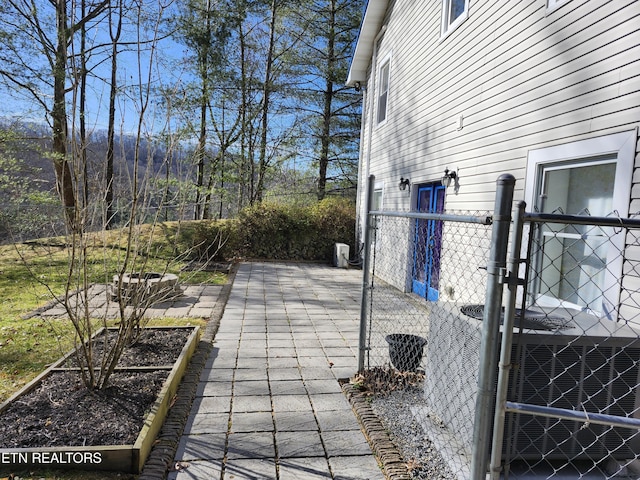 view of patio / terrace with central AC, a vegetable garden, and fence