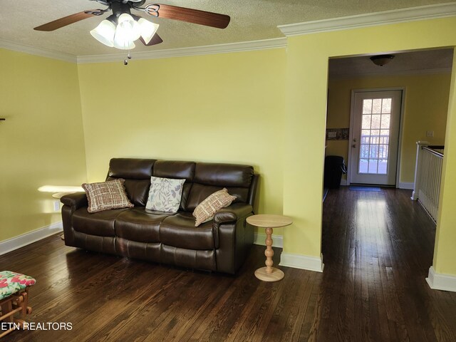 living room with hardwood / wood-style flooring, a textured ceiling, baseboards, and crown molding