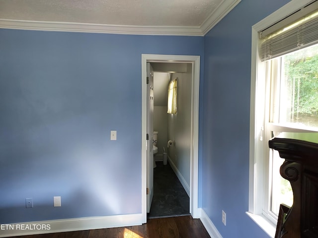 interior space featuring baseboards, dark wood finished floors, and crown molding