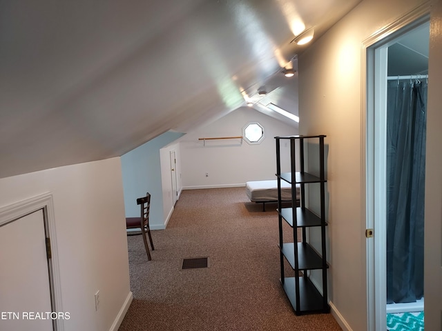 additional living space featuring vaulted ceiling, carpet floors, visible vents, and baseboards