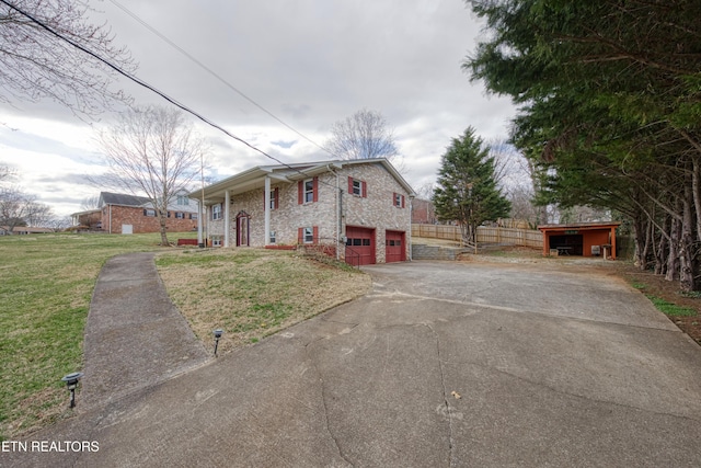 view of front of property with a front yard, driveway, an attached garage, and fence