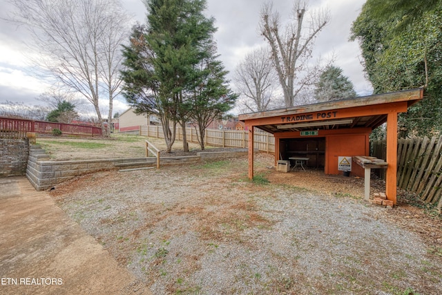 view of yard with an outbuilding, an outdoor structure, and fence