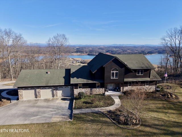 view of front facade featuring an attached garage, covered porch, a water view, and concrete driveway