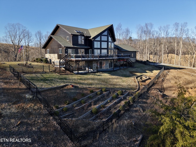 rear view of property with a lawn, a wooden deck, and stairs