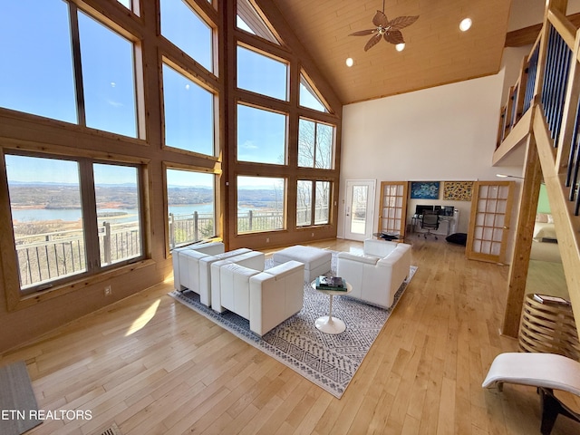 living area with a ceiling fan, wood ceiling, a water view, light wood-type flooring, and high vaulted ceiling