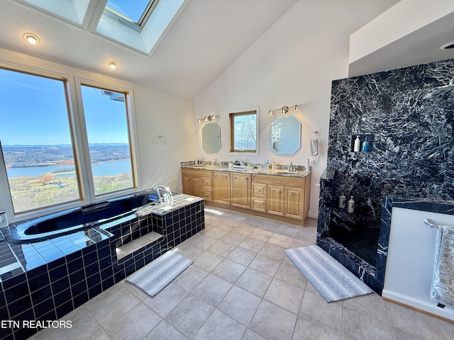 full bathroom with a garden tub, tile patterned flooring, a sink, double vanity, and lofted ceiling with skylight