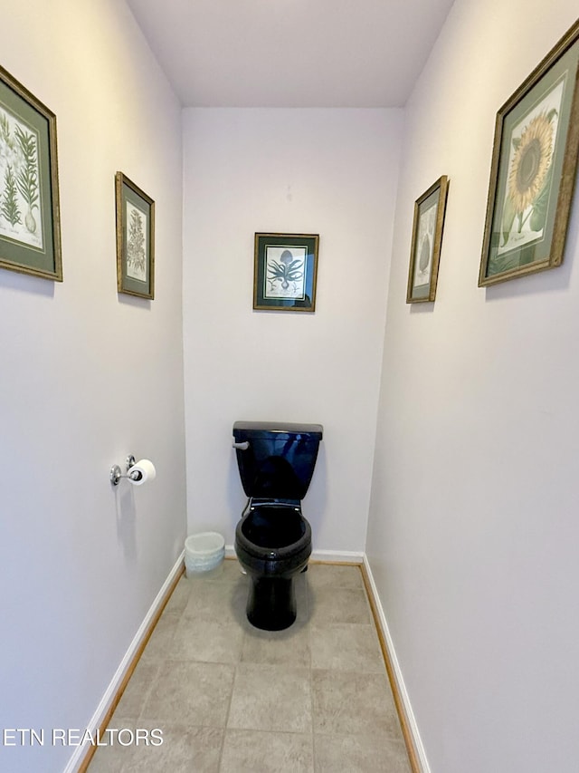 bathroom with toilet and baseboards