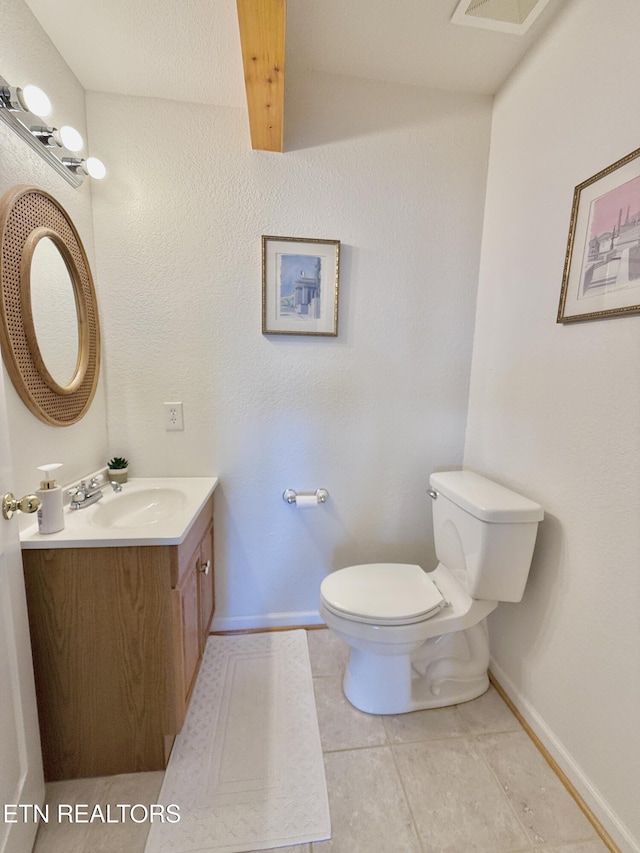 bathroom featuring baseboards, vanity, toilet, and tile patterned floors