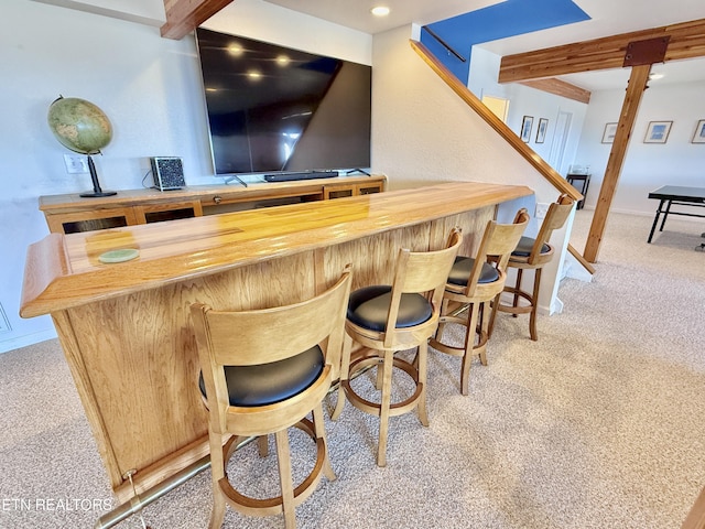 bar with a dry bar, light colored carpet, stairway, beamed ceiling, and baseboards