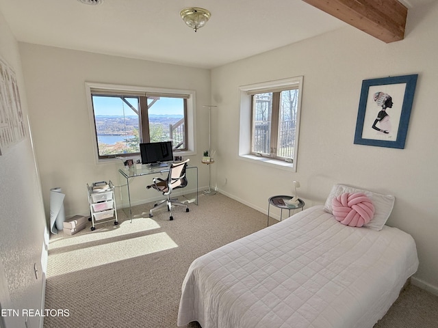 carpeted bedroom featuring multiple windows, beamed ceiling, and baseboards