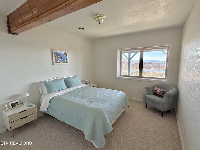 bedroom featuring a textured ceiling, carpet, visible vents, and baseboards