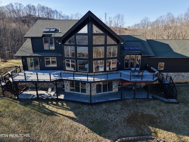 rear view of property featuring a patio area, a shingled roof, stairs, and a wooden deck