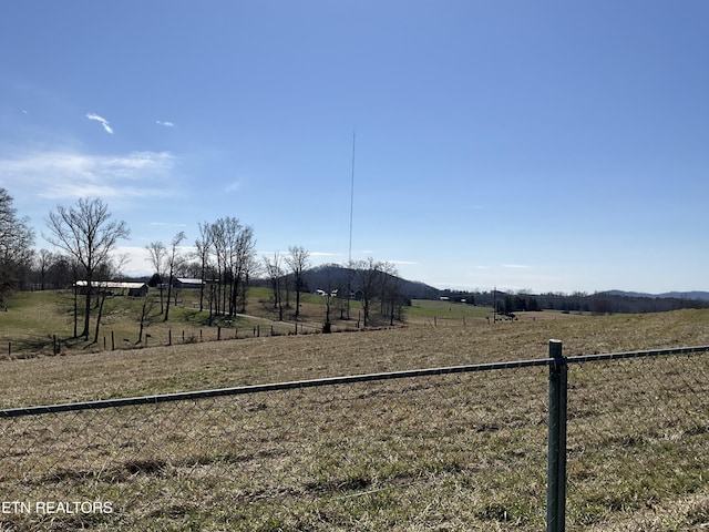 view of yard with a rural view and fence