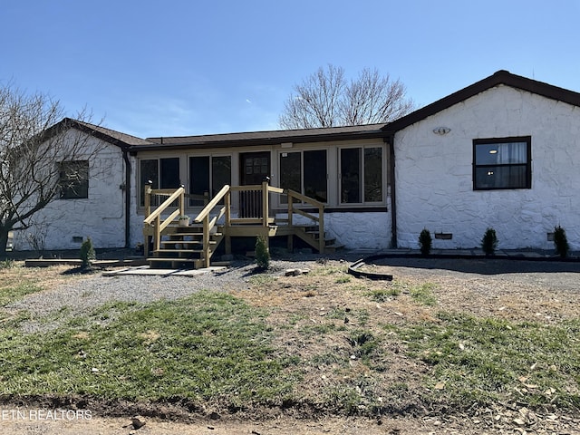 rear view of house with a deck, roof with shingles, and crawl space