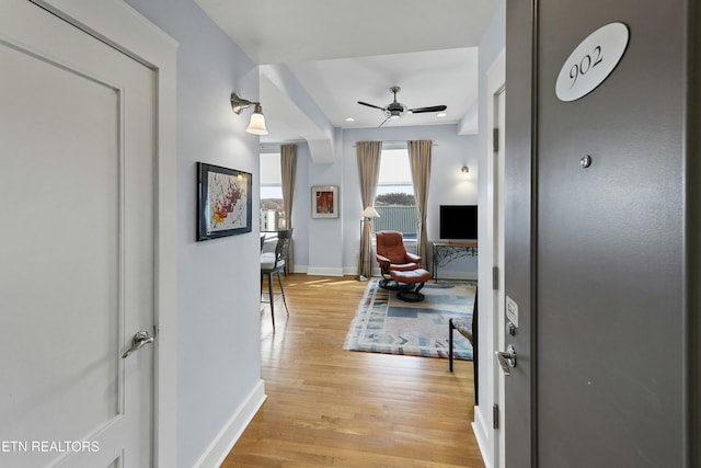 hallway with light wood-style flooring and baseboards